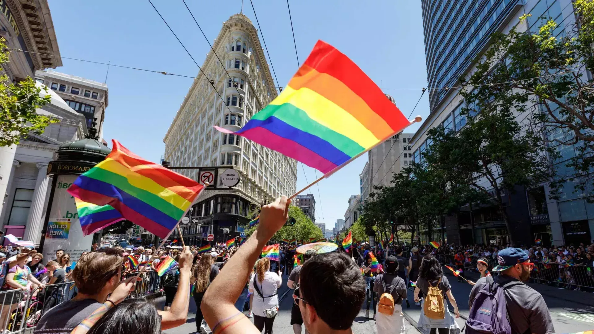 Les gens qui marchent dans le défilé de la fierté de San Francisco brandissent des drapeaux arc-en-ciel.