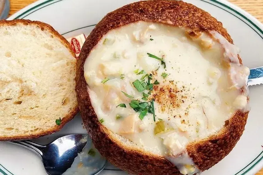 Sopa de almejas servida en un bol de pan de masa fermentada