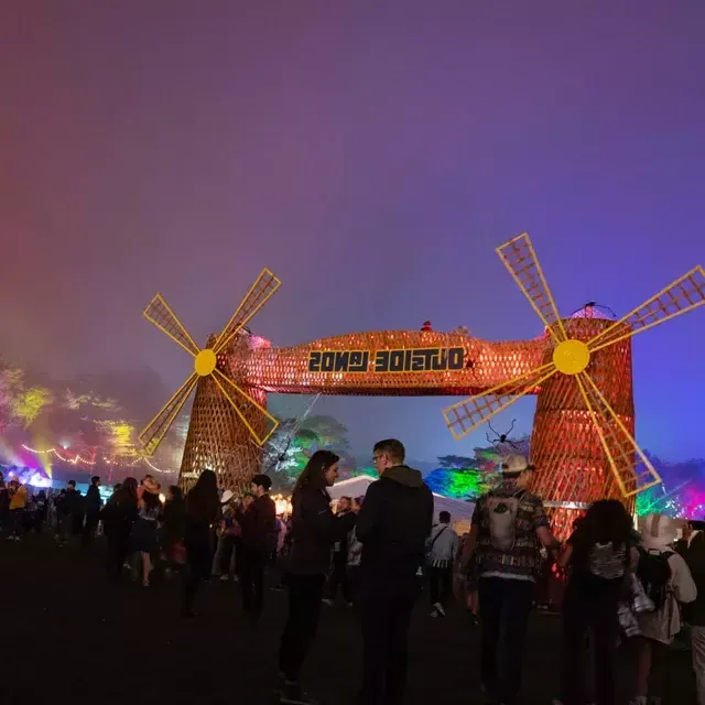 Uma multidão de frequentadores do festival é fotografada à noite em meio às luzes de neon no festival de música Outside Lands, em São Francisco.